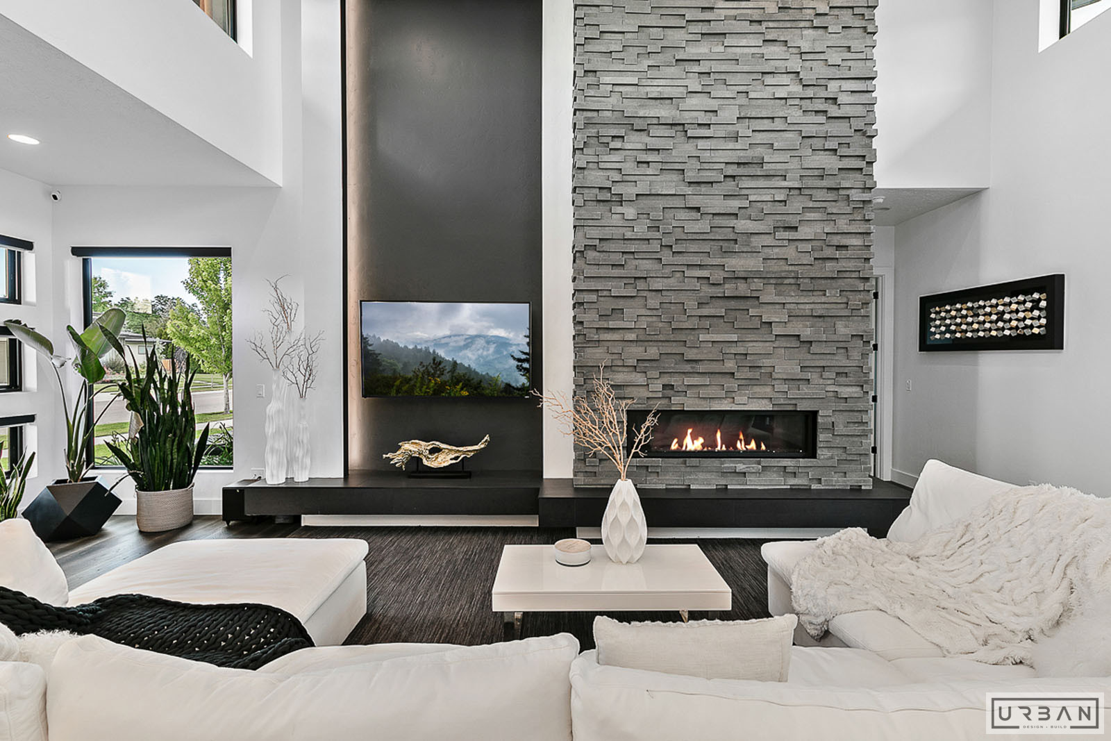 A finished living room with a full height stone fireplace