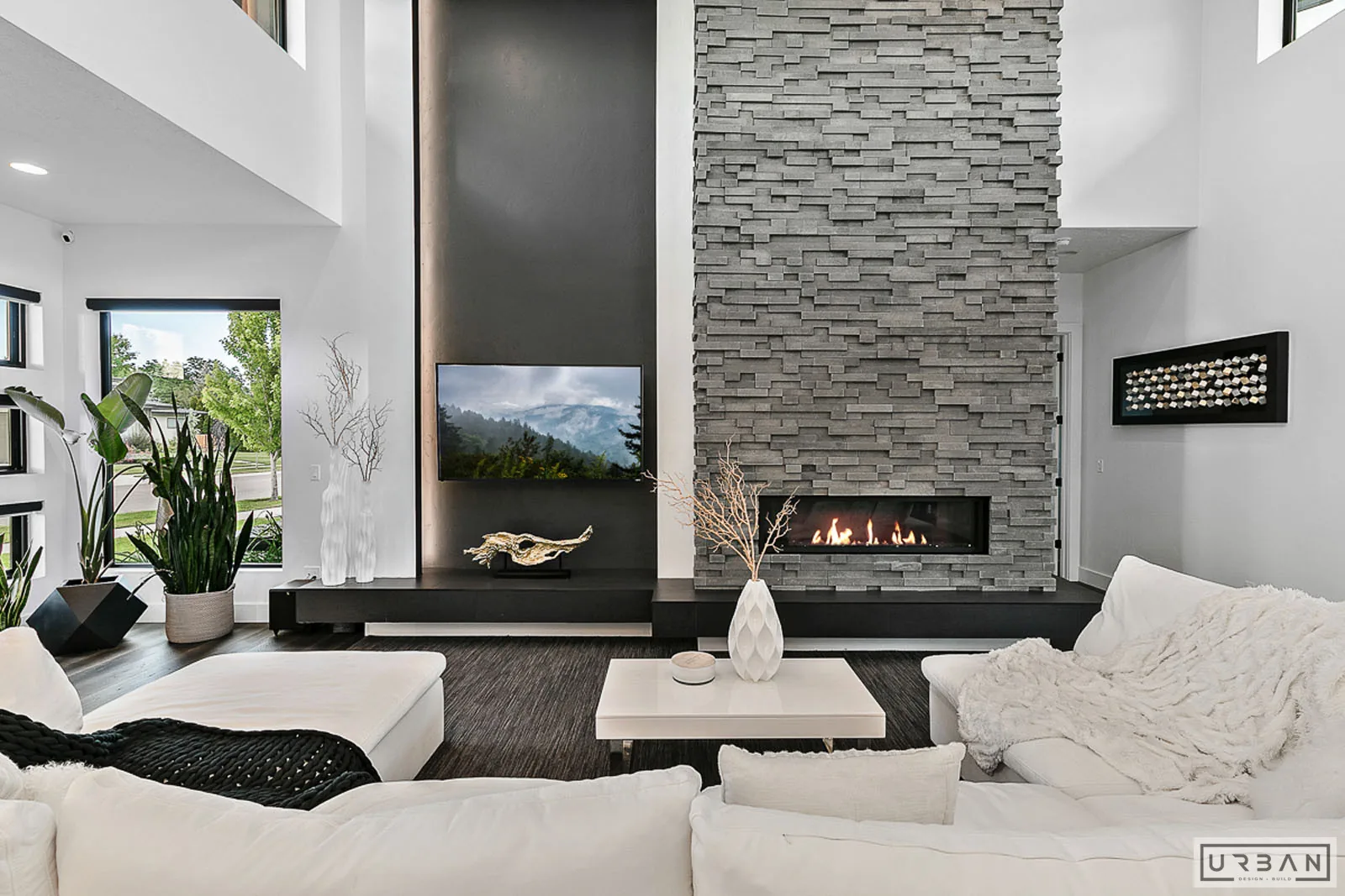 A finished living room with a full height stone fireplace